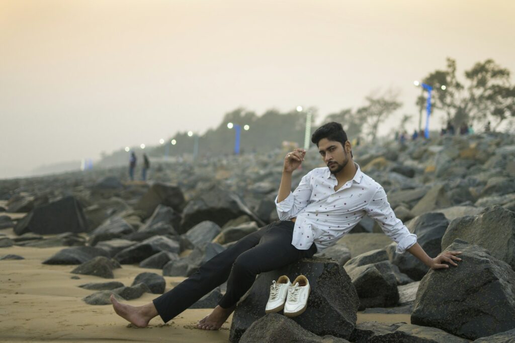 a seller sitting on a rock on the beach after successfully submitting their Fiverr W-9